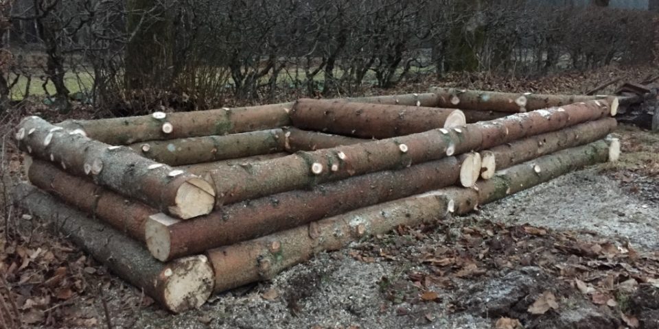 Upphöjd plantering med granstockar